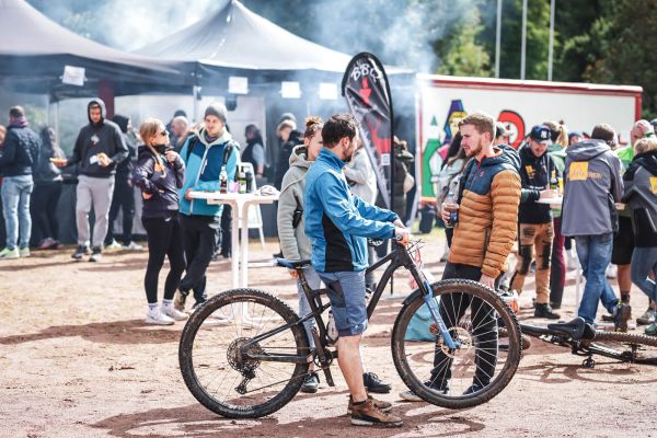 Besucher und Teilnehmende bei Zelten und Verpflegung, Mountainbike im Vordergrund
